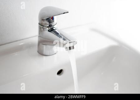 il rubinetto dell'acqua corrente ad un lavabo, l'igiene e il lavaggio delle mani è una misura preventiva importante contro l'infezione del coronavirus, lo spazio di copia, il foc selezionato Foto Stock