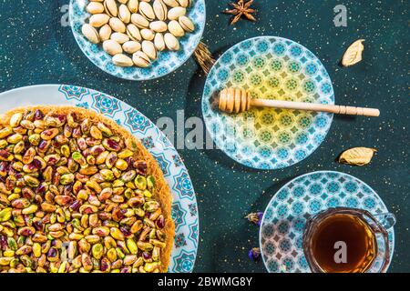 Vista dall'alto del tavolo con dessert orientale con pistacchi e miele Foto Stock