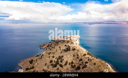 Vista aerea sui pendii terrazzati dell'isola di Taquile sul lago Titicaca con altre isole sullo sfondo. La vista più alta del lago navigabile al mondo. Foto Stock