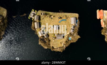 Foto aerea dall'alto di un'isola galleggiante isolata sul lago Titicaca senza turisti o persone, case visibili e una barca di Totora Foto Stock