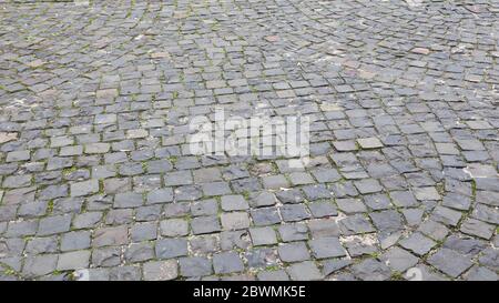 Vista laterale dei ciottoli della strada. Foto dettagliata del fondo stradale. Opere d'arte tradizionali su strade e marciapiedi nella parte vecchia del cit Foto Stock