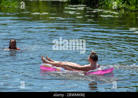 La gente continua a radunare a Warleigh Weir sul fiume Avon vicino a Bath nel Somerset nonostante il punto di bellezza sia attualmente chiuso al pubblico. Foto Stock