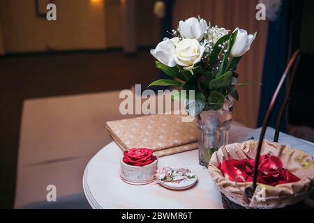 bouquet di rose bianche in vaso di vetro su tavola grigia e tavolo da cucina Foto Stock
