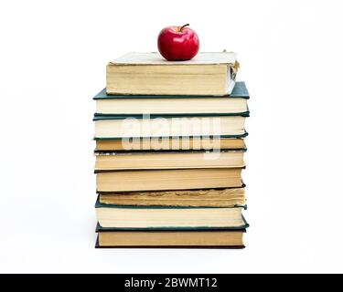 una pila di vecchi libri. Una mela rossa si trova in cima. Il concetto di un'idea è venuto come una mela di Newton. Su sfondo bianco Foto Stock