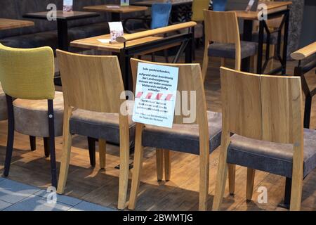 Ratzeburg, Germania, 20 marzo 2020: Le sedie si trovano di fronte a una caffetteria e un massaggio tedesco mostra che è stato chiuso a causa della diffusione di co Foto Stock