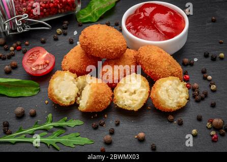 Mozzarella fritta, bocconcini di formaggio cheddar, palle con ketchup Foto Stock