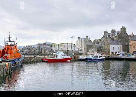 Porto con barche da pesca, bagnino e edifici sullo sfondo, Lerwick, Isole Shetland, Scozia. Foto Stock