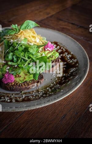 Avocado Sandwich con hummus di barbabietola - avocado e humus affettati su pane tostato di segale per una colazione o uno spuntino sano Foto Stock