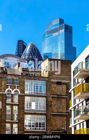 Grattacieli contemporanei nella città di Londra visibili dietro magazzini e blocchi residenziali a Spitalfields, Londra, Regno Unito Foto Stock