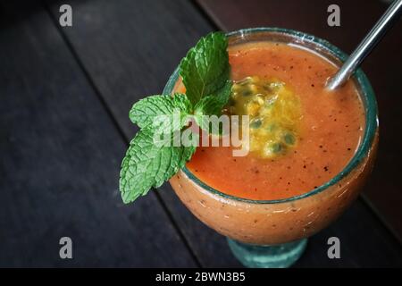 Frullato di papaya con frutto della passione in vetro sul tavolo in un cafe tropicale Foto Stock