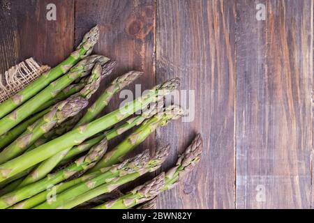 Mazzetto di freschi Asparagi verdi spears su una tavola in legno rustico Foto Stock