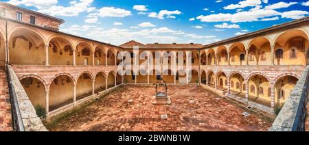 Vista panoramica con lo scenografico cortile nel convento della Basilica di San Francesco, Assisi, Italia. Del Patrimonio mondiale UNESCO dal 2000 Foto Stock