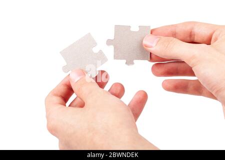 Mani che si uniscono, collegando due pezzi di puzzle verghe, unendo parti di raccordo corrispondenti, elementi isolati su bianco, ritagliati Foto Stock