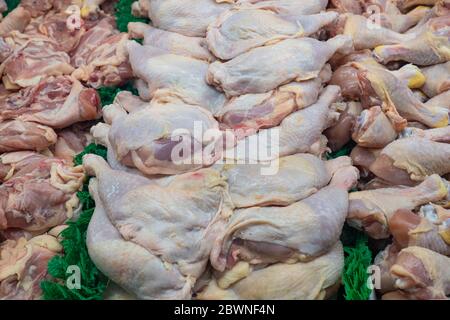 carne di pollo cruda sull'osso con pelle in una custodia presso il macellaio Foto Stock