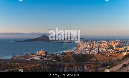 Paesaggio urbano. Vista panoramica della città di Las Palmas de Gran Canaria al tramonto con la spiaggia di Las Canteras e le montagne la Isleta sullo sfondo Foto Stock