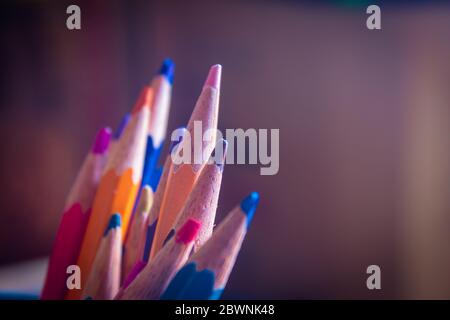 Matite colorate impilate insieme in un supporto. Forniture per studenti d'arte. Foto Stock