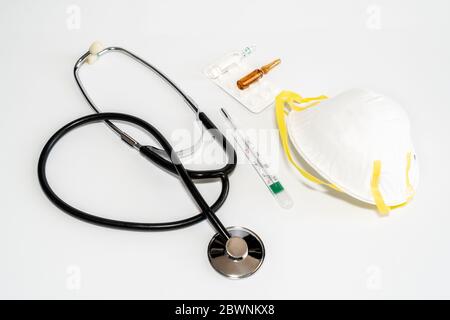 Maschere mediche con elastico, termometro, medicina e stetoscopio, isolate su sfondo bianco. Concetto sanitario e medico. Foto di alta qualità Foto Stock