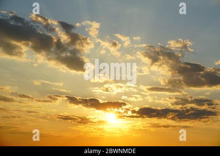 Cielo tramonto con nuvole e travi soleggiate. Cielo tramonto sfondo. Foto Stock