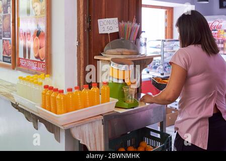 Rodi, Grecia - 14 maggio 2018: Una donna spreme il succo d'arancia e vende per strada a Lindos, sull'isola di Rodi. Grecia Foto Stock