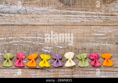 Pasta biologica colorata su sfondo di legno. Foto Stock