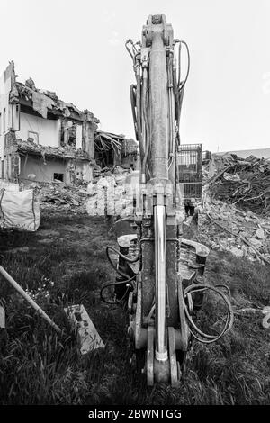 Parcheggio per escavatori prima di demolire l'edificio. Scatti grandangolari in bianco e nero. Foto Stock