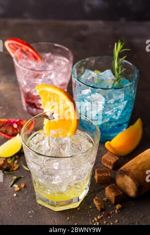 Set di cocktail colorati con frutta ed erbe, zucchero di canna su fondo di pietra Foto Stock