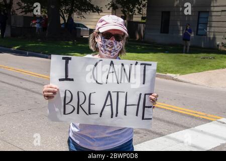 05-30-2020 Tulsa USA Donna in rosa cappuccio palla e maschera stampata tenendo il segno di lettura non posso respirare in piedi in mezzo alla strada Foto Stock