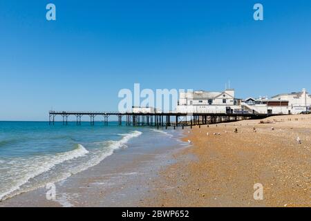 Il molo e la spiaggia di pietra si insolita sul lungomare di Bognor Regis, una cittadina balneare nel Sussex occidentale, costa meridionale dell'Inghilterra in una giornata di sole con cielo blu Foto Stock