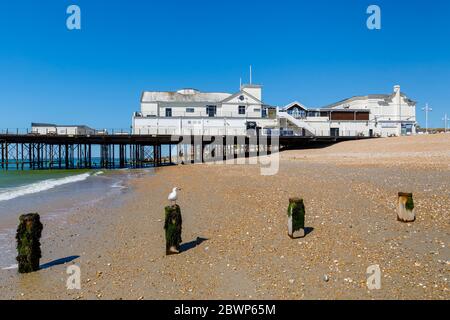 Il molo e la spiaggia di pietra si insolita sul lungomare di Bognor Regis, una cittadina balneare nel Sussex occidentale, costa meridionale dell'Inghilterra in una giornata di sole con cielo blu Foto Stock