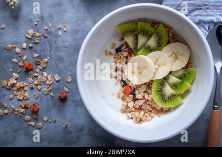 Granola fatta in casa con uvetta, albicocche secche e noci. Granola con uvetta, albicocche secche, noci, banana, kiwi e yogurt Foto Stock