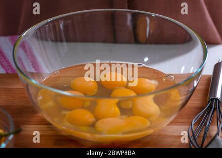 Sbattendo le uova con una frusta. Ciotola con le uova prima di montare Foto Stock