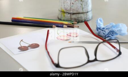 attrezzature per arti visive per la dimostrazione in classe da parte dell'insegnante. Le vernici acquose pennellano carta e matite su una scrivania o un tavolo nella sala d'arte Foto Stock