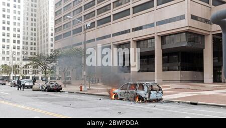 Una macchina in fiamme si trova sulla strada fuori del Cleveland Justice Center a Cleveland, Ohio, Stati Uniti come uno dei molti che sono stati vandalizzati durante il 2020 maggio 30 Black Lives Matter Movement Gathering. Il Centro di Giustizia, sede della polizia di Cleveland, è stato vandalizzato come manifestanti riuniti dopo una marcia pacifica e sono stati incontrati con la polizia utilizzando gas lacrimogeni e altre tattiche pesanti per disperdere il gruppo. Foto Stock