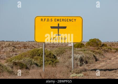 Il segnale Royal Flying Doctor Emergency Service che indica la strada può essere utilizzato anche come striscia di atterraggio in un'emergenza medica. Catturato in Australia Occidentale Foto Stock