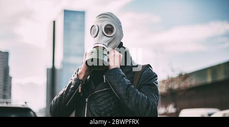 giovane uomo che indossa una maschera a gas su una strada della città Foto Stock