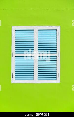 Tradizionale vetrina vintage Singapore con antiche persiane blu e bianco in legno su parete verde nella storica Little India Foto Stock