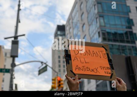 Protestante alla marcia per George Floyd a Lower Manhattan il 6/2/2020 con un cartello che dice 'dismantle all antinblack Systems' Foto Stock