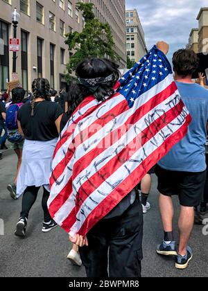 Un giovane indossa una bandiera americana in una marcia contro l'assassinio di George Floyd da parte della polizia, Washington, DC, Stati Uniti, giugno 2020 Foto Stock