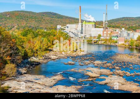 L'ambiente idilliaco del torrente e delle cascate Rumford è in conflitto con la fabbrica industriale circondata da splendide colline boschive e colori autunnali. Foto Stock