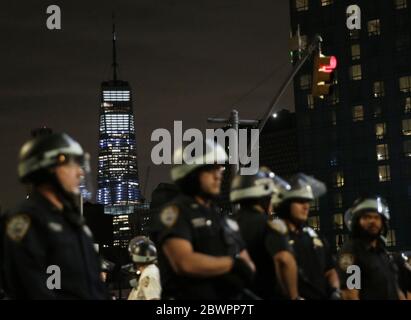 La guglia in cima al One World Trade Center è buia per Blackout Martedì come ufficiali di polizia della NYPD in marcia riot fermare i dimostranti di entrare Manhattan a Manhattan Bridge un'altra notte di disordini a Manhattan come proteste, Saccheggi e saccheggi in tutto il paese continuano la morte di George Floyd per mano della polizia di Minneapolis a New York il 2 giugno 2020. L'ex poliziotto di Minneapolis Derek Chauvin è stato arrestato venerdì giorni dopo la messa in circolazione del video di lui che ha tenuto il ginocchio al collo di George Floyd per più di otto minuti prima che Floyd morì. Tutti e quattro gli ufficiali invol Foto Stock