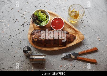 Costolette di maiale grigliate su tavola di legno. Foto Stock