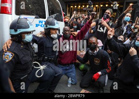 Ufficiali di polizia inginocchiati accanto a un uomo nero a sostegno delle proteste contro la morte di George Floyd durante una protesta a New York City negli Stati Uniti questo Martedì, 02. Le proteste in tutto il paese sono state motivate dopo la morte di George Floyd il 25 maggio, dopo essere stato asfissiato per 8 minuti e 46 secondi dal poliziotto bianco Derek Chauvin a Minneapolis, Minnesota. Credit: Brazil Photo Press/Alamy Live News Foto Stock