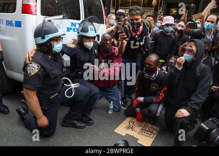 New York, New York, Stati Uniti. 2 Giugno 2020. Ufficiali di polizia inginocchiati accanto a un uomo nero a sostegno delle proteste contro la morte di George Floyd durante una protesta a New York City negli Stati Uniti questo Martedì, 02. Le proteste in tutto il paese sono state motivate dopo la morte di George Floyd il 25 maggio, dopo essere stato asfissiato per 8 minuti e 46 secondi dal poliziotto bianco Derek Chauvin a Minneapolis, Minnesota. Credit: William Volcov/ZUMA Wire/Alamy Live News Foto Stock