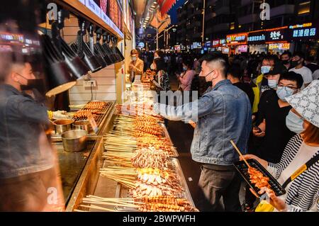 Pechino, la provincia cinese di Jilin. 1 Giugno 2020. La gente compra spuntini in una strada commerciale a Changchun, nella provincia di Jilin della Cina nordorientale, 1 giugno 2020. Le autorità di Changchun hanno introdotto diverse misure per rilanciare l'economia locale, a mano a mano che l'impatto del COVID-19 si è ridotto. Credit: Xu Chang/Xinhua/Alamy Live News Foto Stock