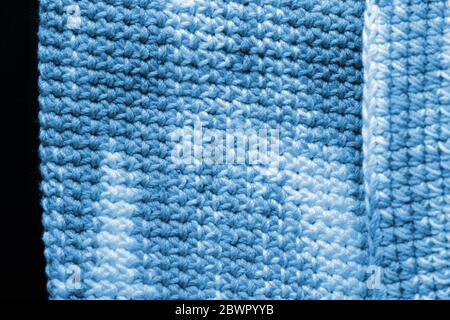 Frammento a crocheted di filo di melange primo piano. Concetto fatto a mano. Astratto sfondo blu colore tonato Foto Stock
