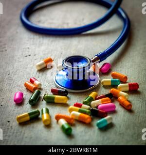 Stetoscopio con un mucchio di pillole di capsule di antibiotici Foto Stock