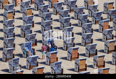 30 maggio 2020, Meclemburgo-Pomerania occidentale, Warnemünde: I primi vacanzieri si siedono in cesti di paglia e godono del sole sulla spiaggia del Mar Baltico a Warnemünde. A Whitsuntide, le regioni di vacanza nel Meclemburgo-Pomerania occidentale si aspettano una maggiore corsa di turisti e visitatori di un giorno. Foto: Jens Büttner/dpa-Zentralbild/ZB Foto Stock