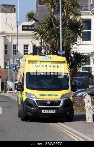 Un'ambulanza del Servizio di ambulanza del Sud Ovest ha parcheggiato fuori le case nel centro di Newquay Town in Cornovaglia. Foto Stock