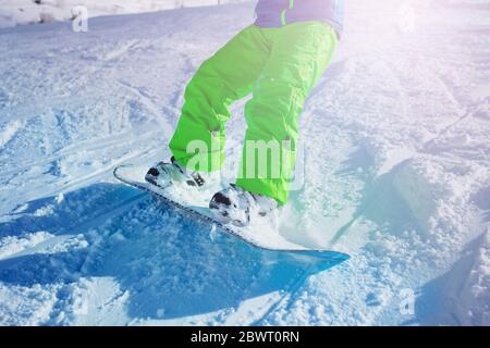 Primo piano dello snowboard del ragazzo in movimento scendendo lungo la pista sulla stazione sciistica di montagna Foto Stock