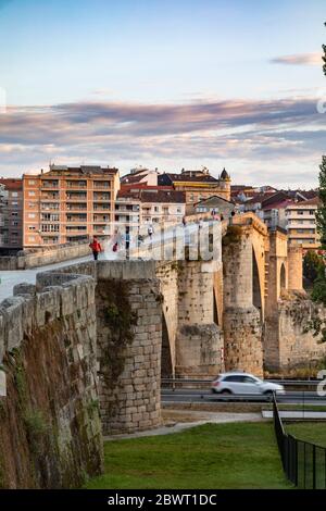 Persone che attraversano il ponte romano di mattina presto, Ourense, Galizia, Spagna.